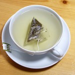 Weisser Bio-Tee mit Wasser in Tasse