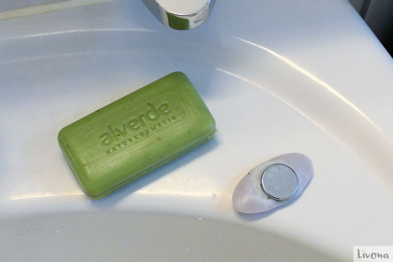 grünes Stück alverde Naturseife und lila Seifenrest mit Magnethalter
