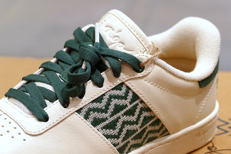 weiße Sneakers mit grünen Schnürsenkeln und Stoffeinsatz