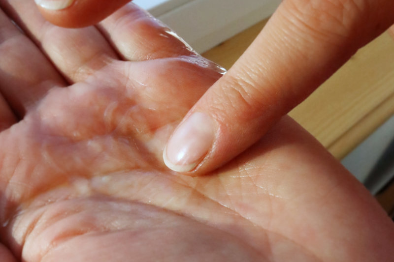 Five Gesichtsöl und Gesichtsserum mit dem Finger in der Handfläche mischen